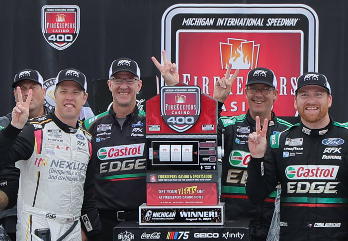Chris Buescher celebrates with RFK Racing co-owner Brad Keselowski and crew chief Scott Graves after winning the NASCAR Cup Series FireKeepers Casino 400 at Michigan International Speedway. (Photo by Jonathan Bachman/Getty Images)
